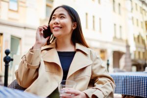 Zufriedene Frau am Telefon, weil sie mit dem telefonischen Services ihrer Arztpraxis sehr zufrieden ist.